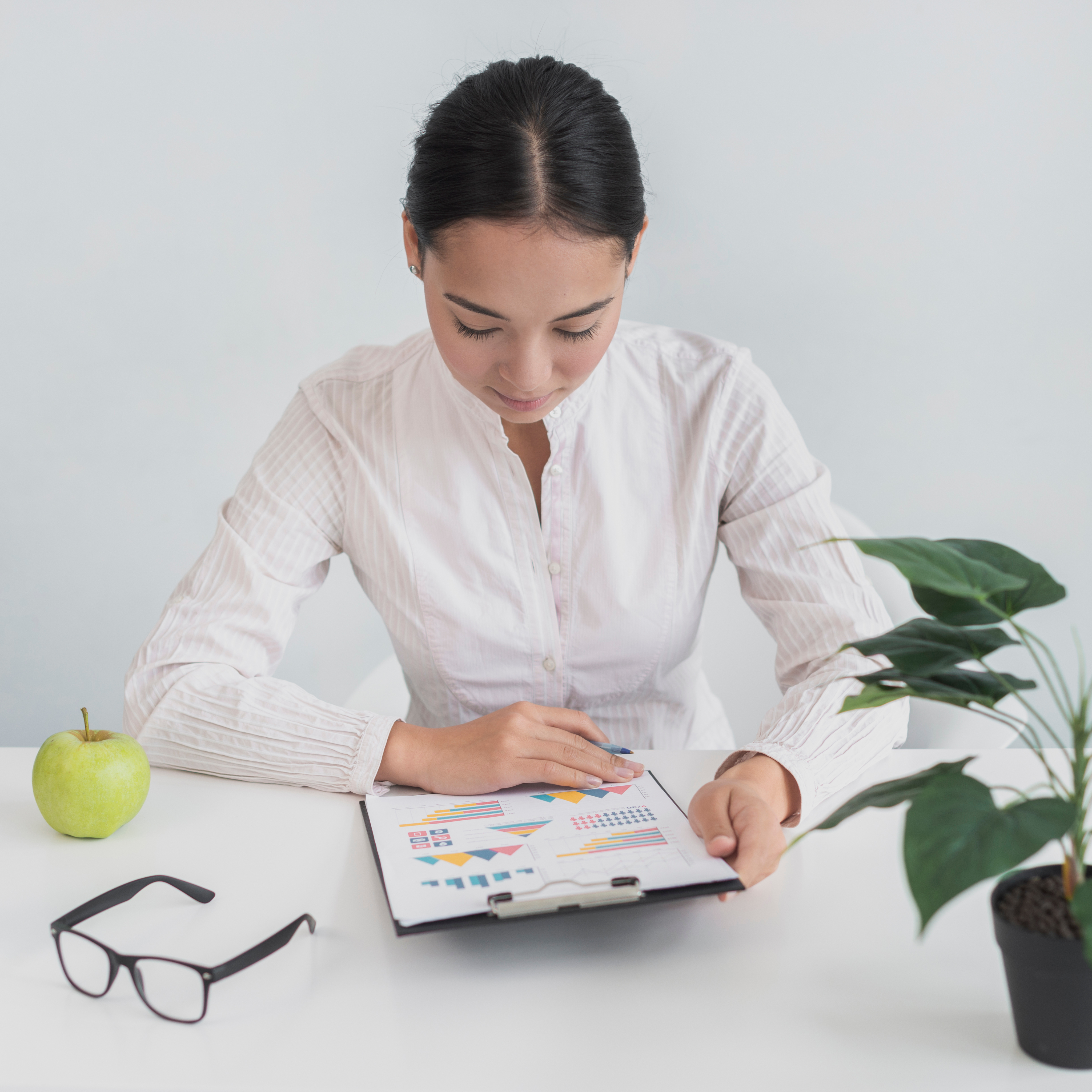 Woman working on a laptop with an apple